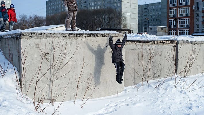 дети прыгают в снег с крыши гаража