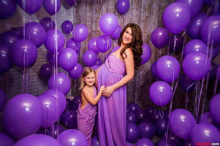 беременная со старшей дочерью среди фиолетовых воздушных шаров