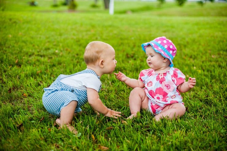 devochka-i-malchik, девочка и мальчик 9 месяцев сидят на травке и пытаются общаться