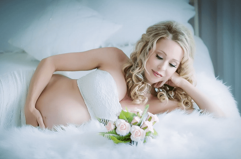 фотосессия беременной на кровати с розами
