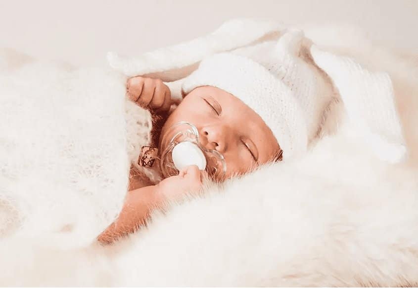 spyaschiy-grudnichok, спящий грудничок в белой шапочке с соской во рту